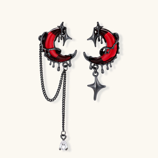 Blood Moon asymmetrical earrings with garnet-red crescent moons, blackened metal, chains and zirconia accents