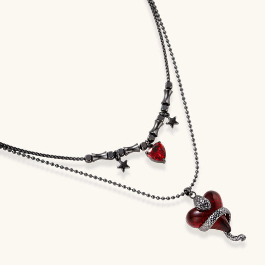 Close detail of Crimson Serpent Hearts necklace showing the layered black chains, red hearts and star accents
